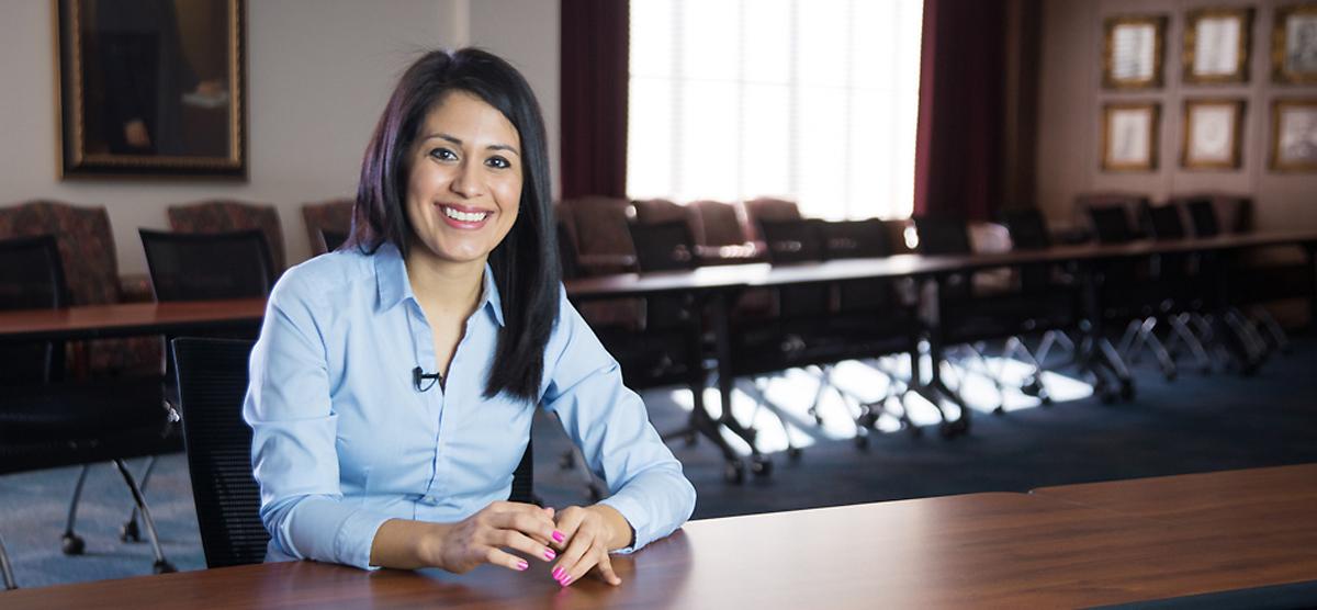 Woman sitting in boardroom.