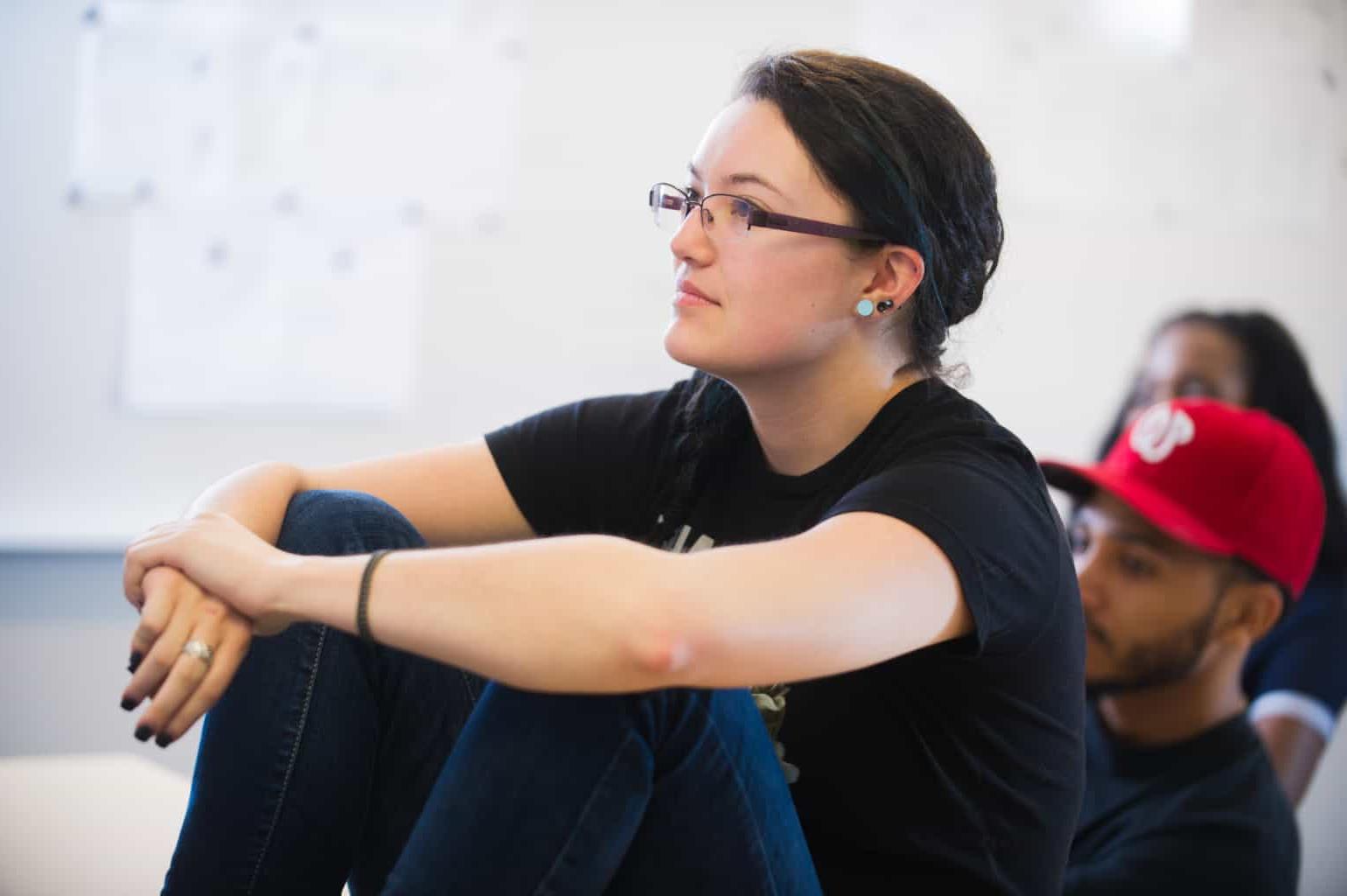 Student sitting on desk listening