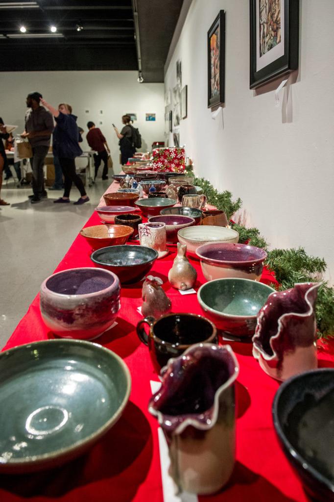 Ceramic art pieces on tables in art gallery.