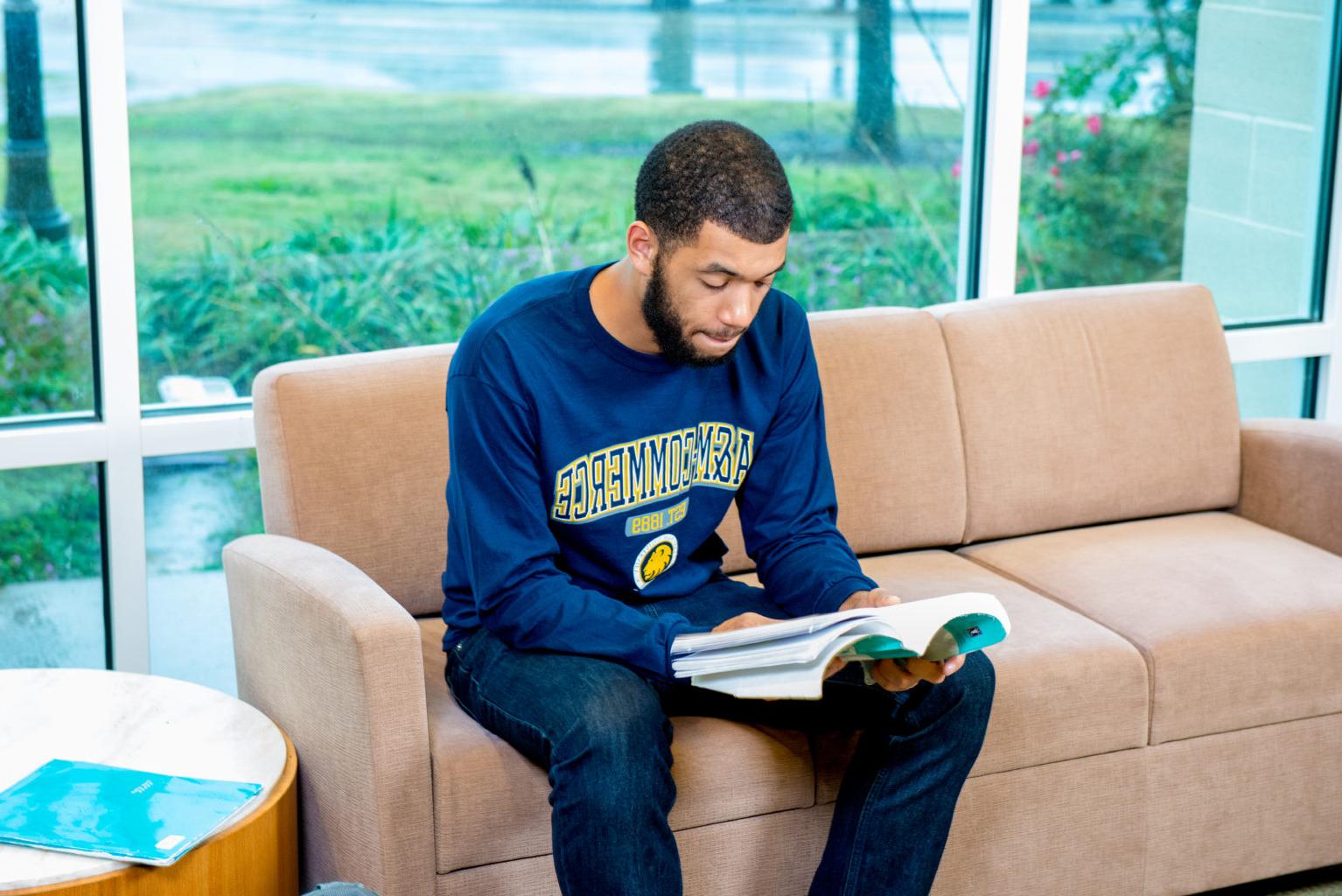 Student reading out of a textbook. 