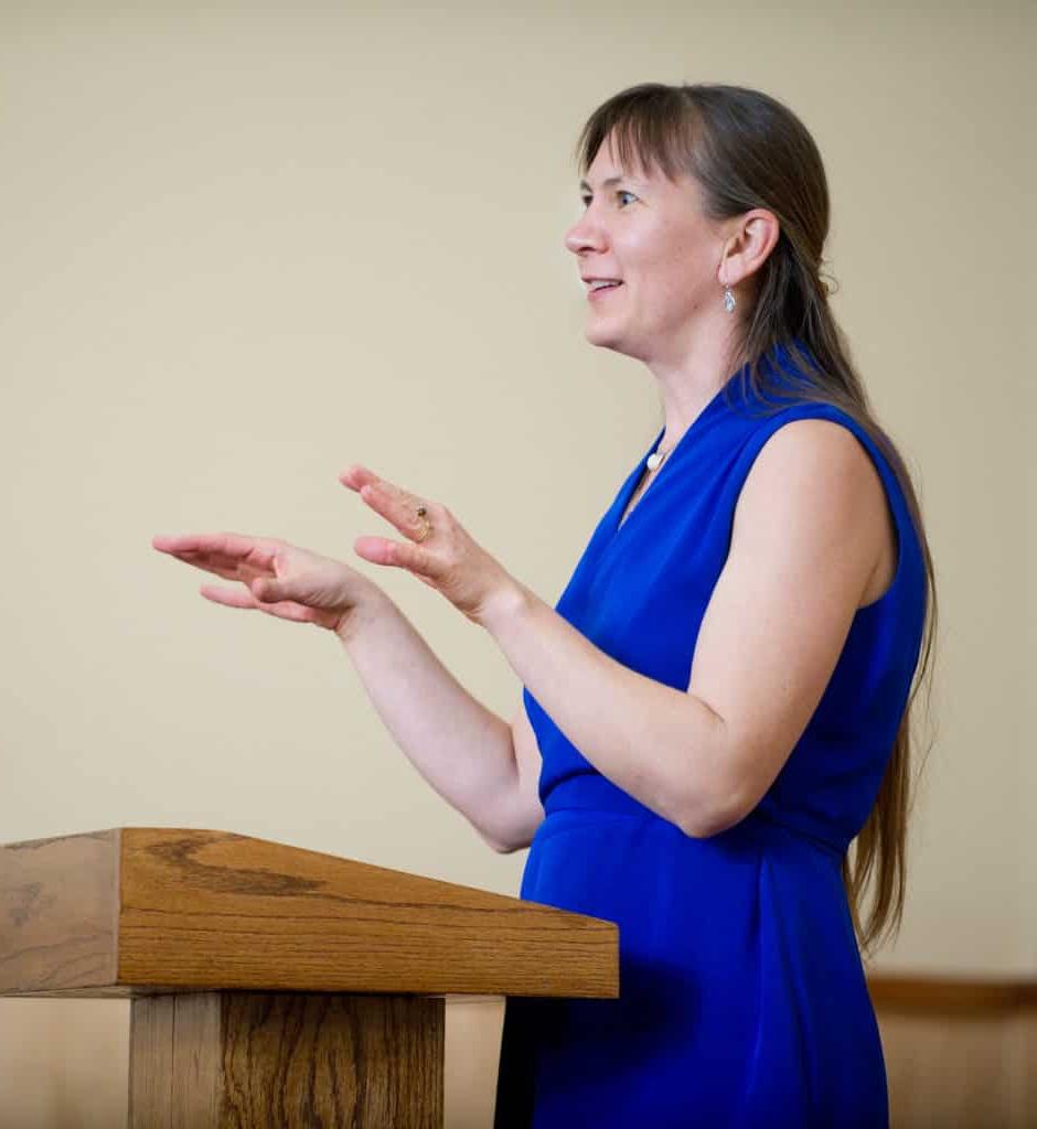 Woman giving a speech at a podium.