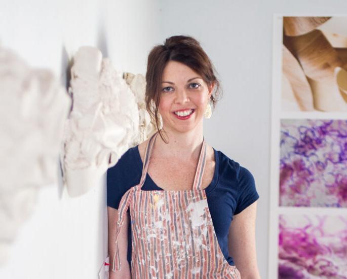 Josie Durkin art professor standing in front of ceramic art.