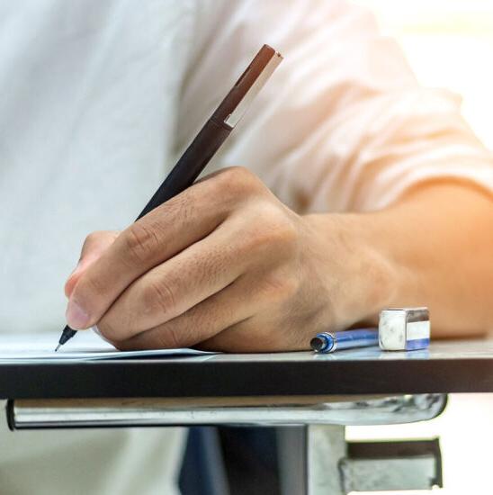 School exam student's taking educational admission test in class, thinking hard, writing answer in university classroom, education and world literacy day concept