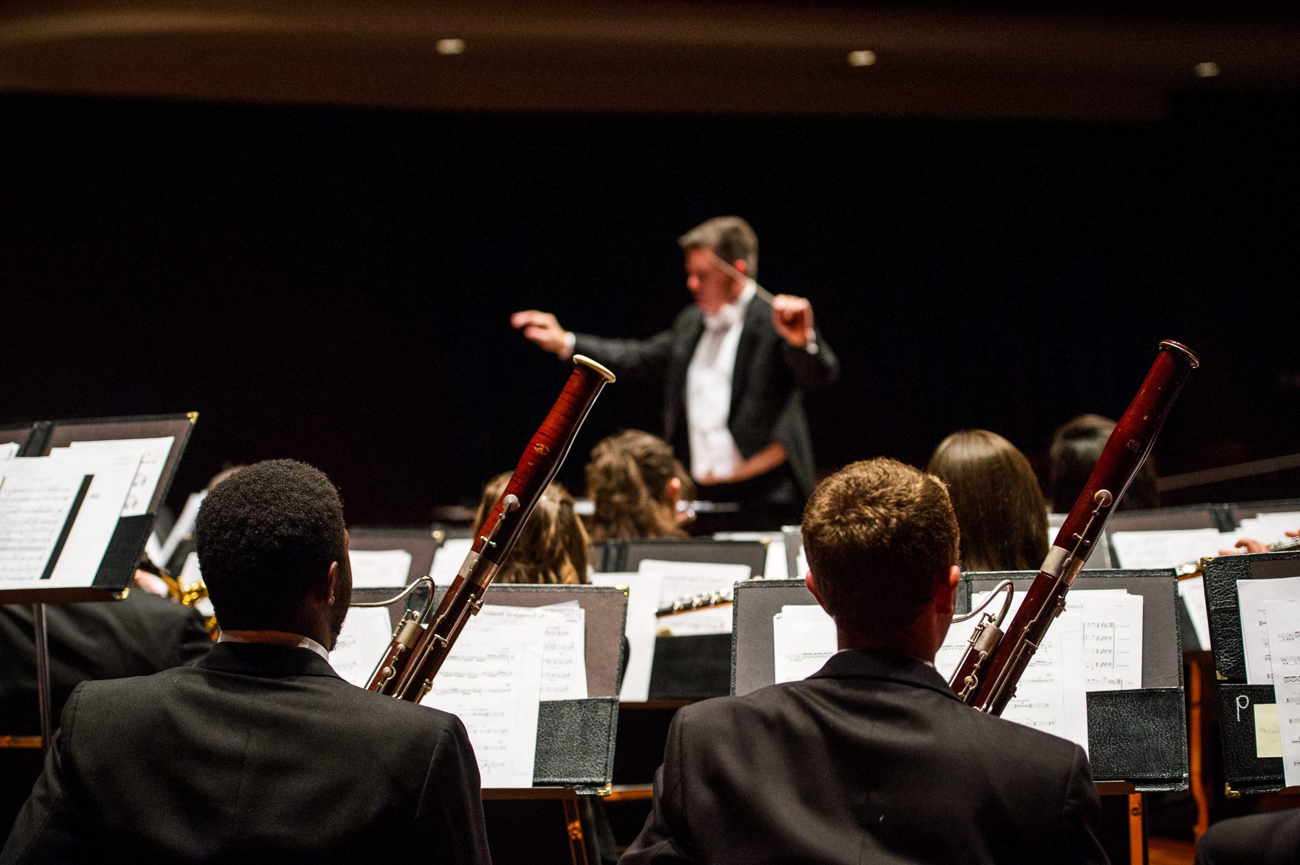 A male maestros conducting an orchestra.