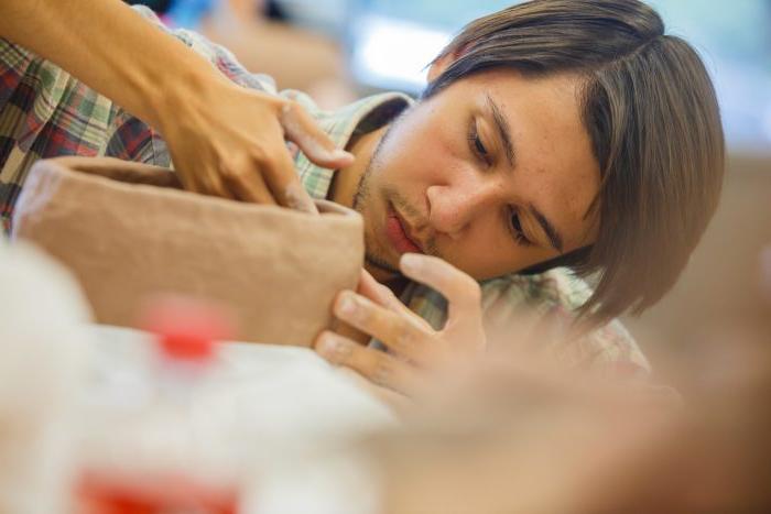 A male student working on clay.