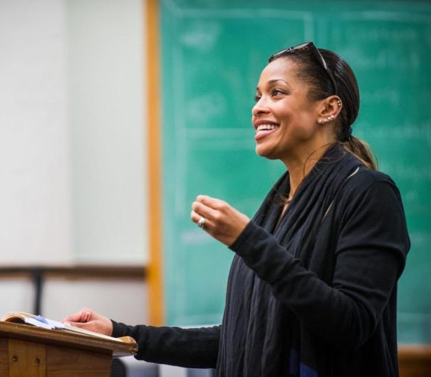 A female professor lecturing in a classroom.