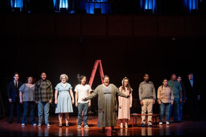 A chorus performing on stage during a musical.